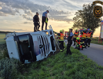 Kamion skončil po nehodě převrácený v poli
